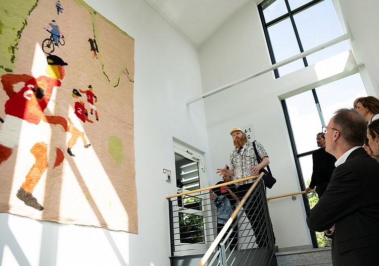 Marlon Wobst vor seiner Filzarbeit „Runtastic” im Treppenaufgang zur Station 1b der DRK Kliniken Berlin Westend