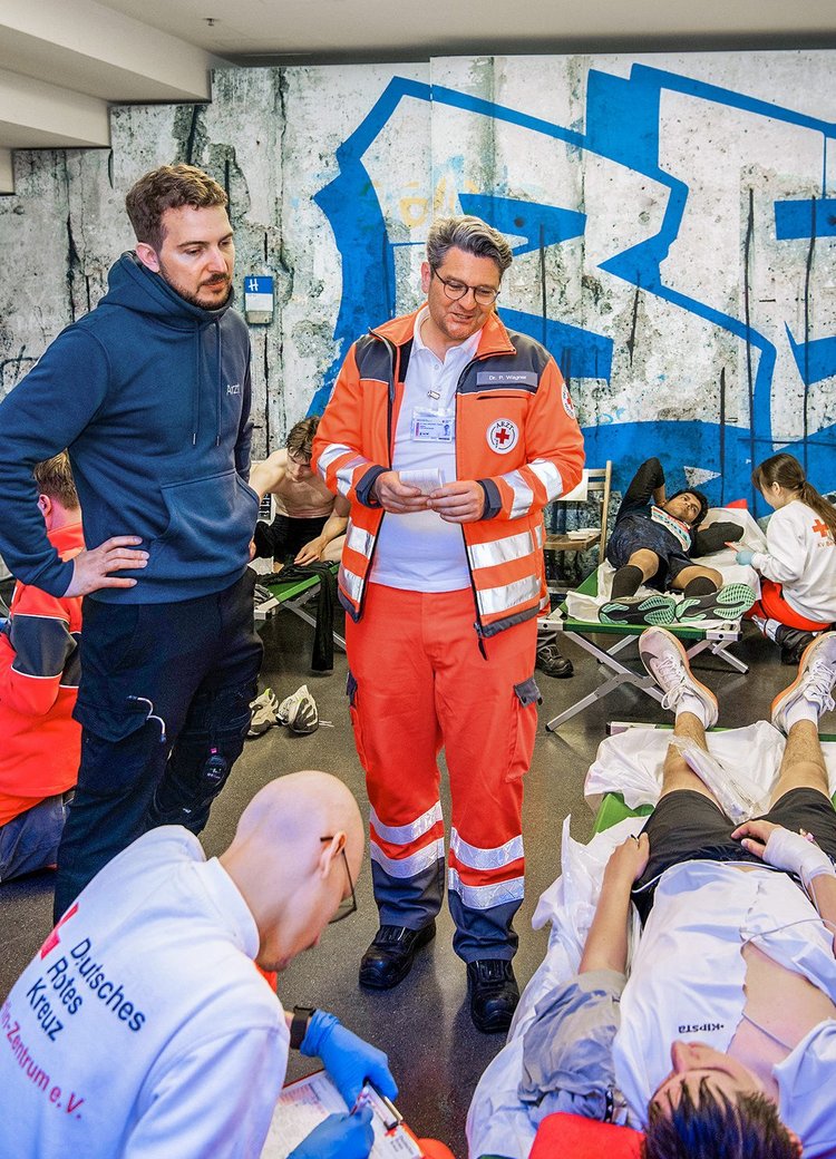 Rennarzt mit Kollegen, die Läufer versorgen.
