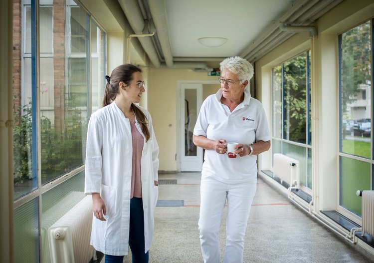Eine Ärztin im Ruhestand im Gespräch mit einer jungen Ärztin
