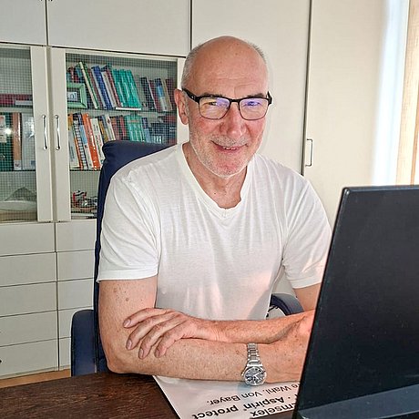 Dr. med. Damian Zydra am Schreibtisch in seinem Behandlungszimmer