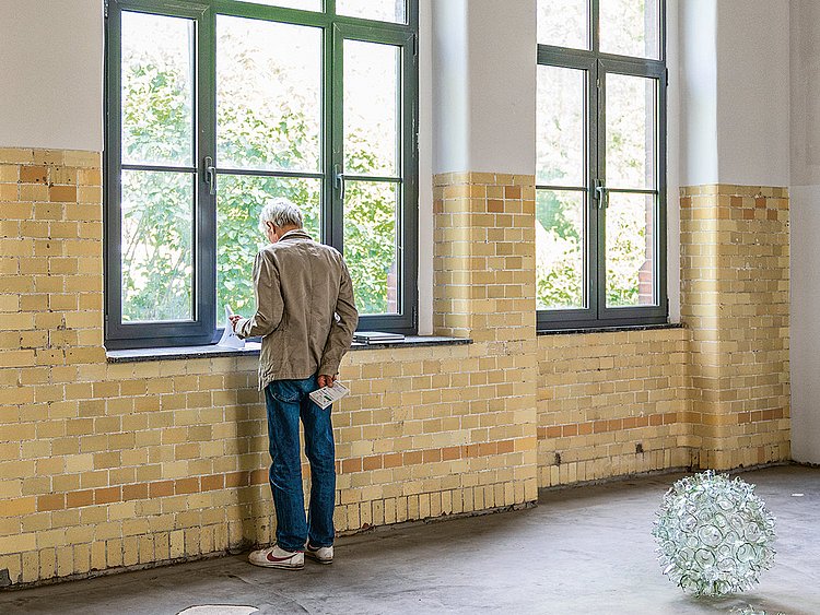 Mann steht am Fenster des historischen Kochhauses der DRK Kliniken Berlin Westend
