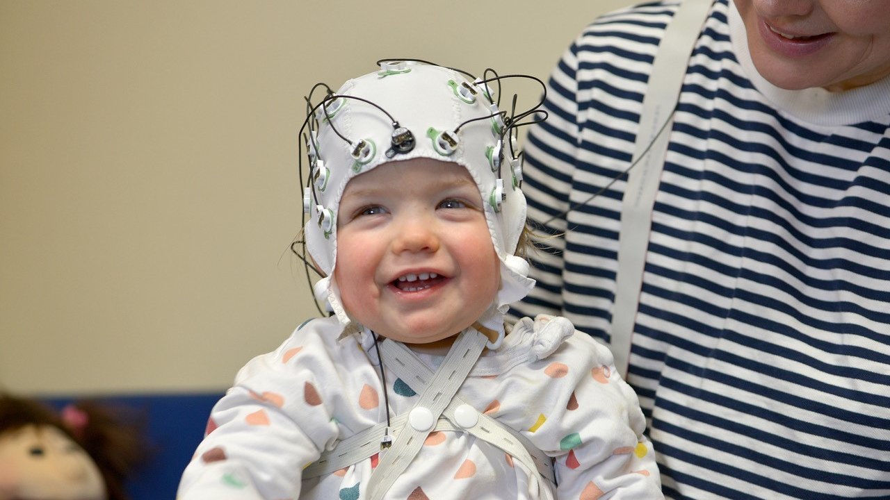 Ein Kleinkind mit einer EEG-Haube.